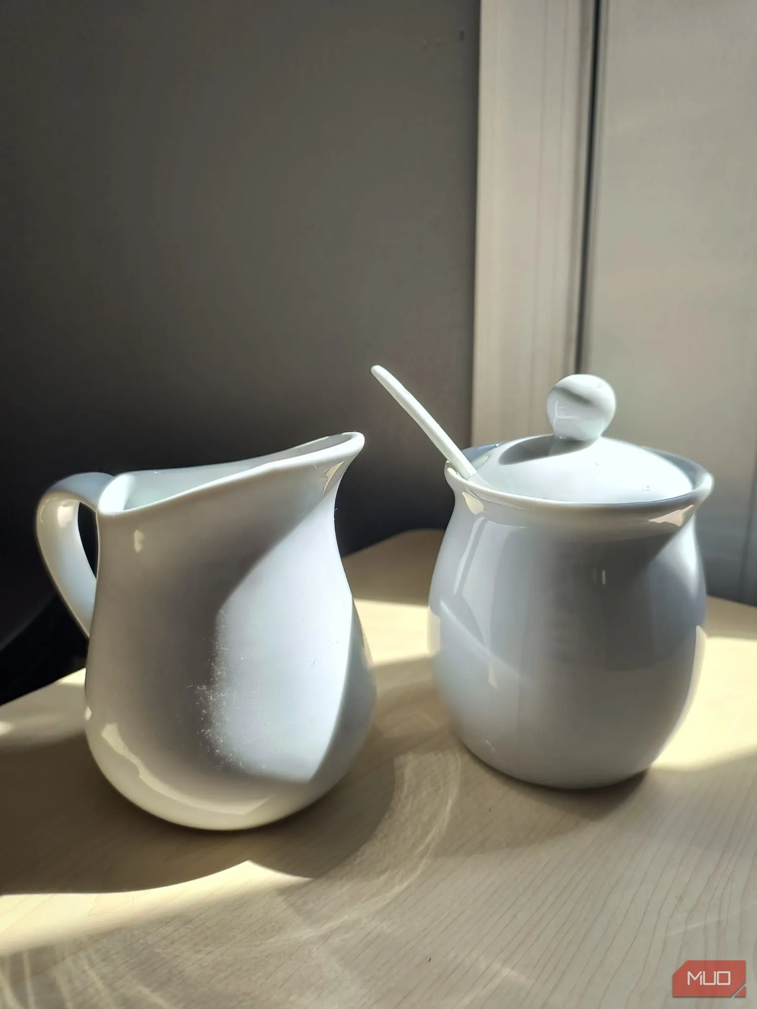 [Ảnh có HDR] Bộ sứ trắng đựng đường và kem dưới ánh nắng trực tiếp, phản chiếu được kiểm soát tốt
