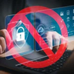 Bàn tay đang gõ laptop với biểu tượng bảo mật và dấu cấm màu đỏ, tượng trưng cho rủi ro bảo mật mật khẩu yếu.