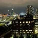 Bố cục ảnh panorama với khung cảnh thành phố về đêm, nhấn mạnh việc chọn điểm lấy nét.