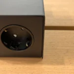 Bộ sạc điện thoại và cáp USB đang sạc tại bàn ở sân bay, giúp tiết kiệm pin khi di chuyển.