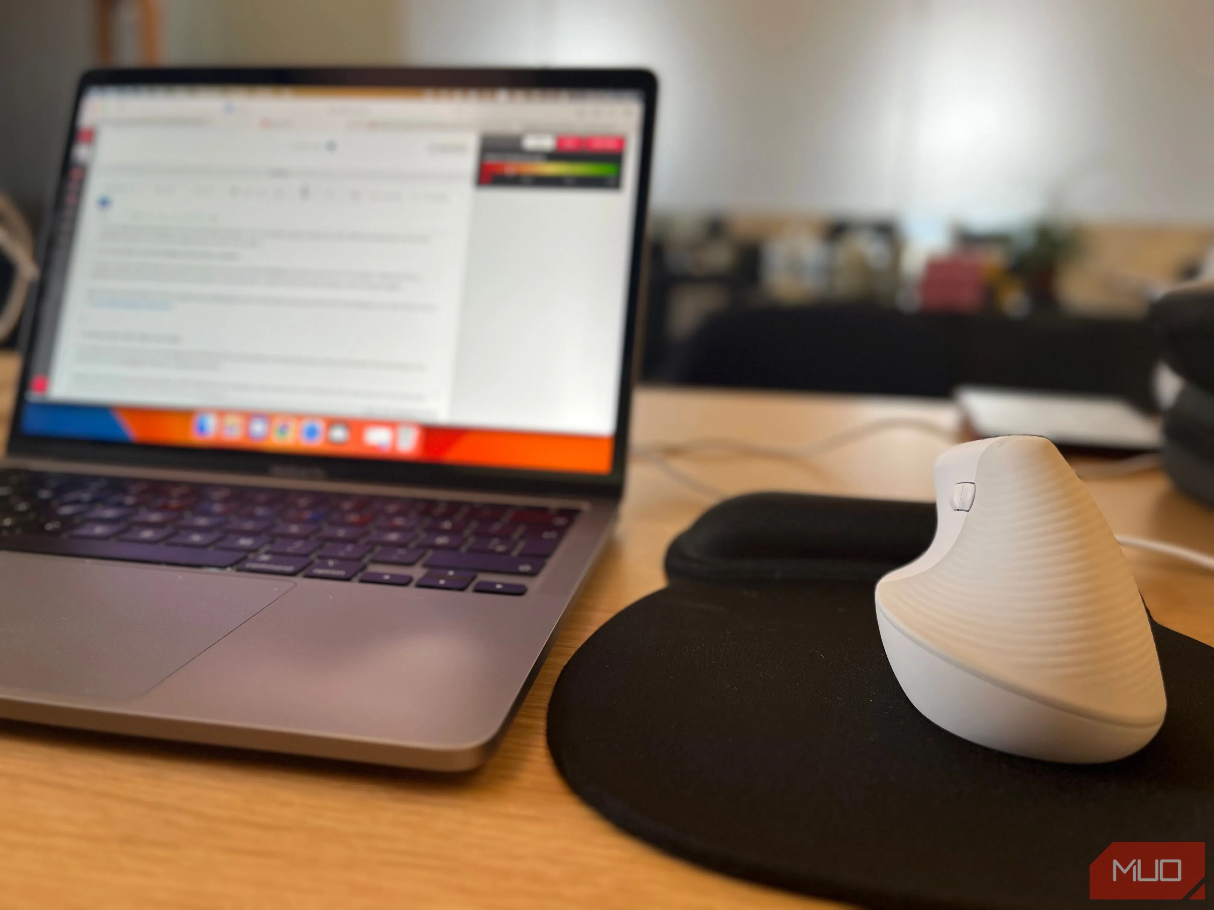 Chuột không dây cùng laptop trên bàn làm việc linh hoạt tại không gian coworking