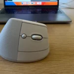 Chuột không dây Logitech Lift gần máy tính xách tay trên bàn làm việc, tối ưu ergonomics