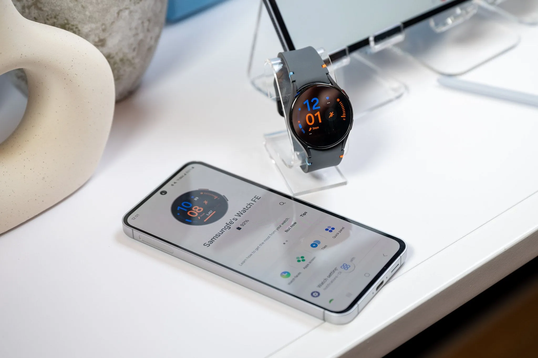 Điện thoại Samsung Galaxy S24 FE đang sạc cho Galaxy Watch LTE qua cổng USB-C, minh họa tính năng sạc ngược khẩn cấp