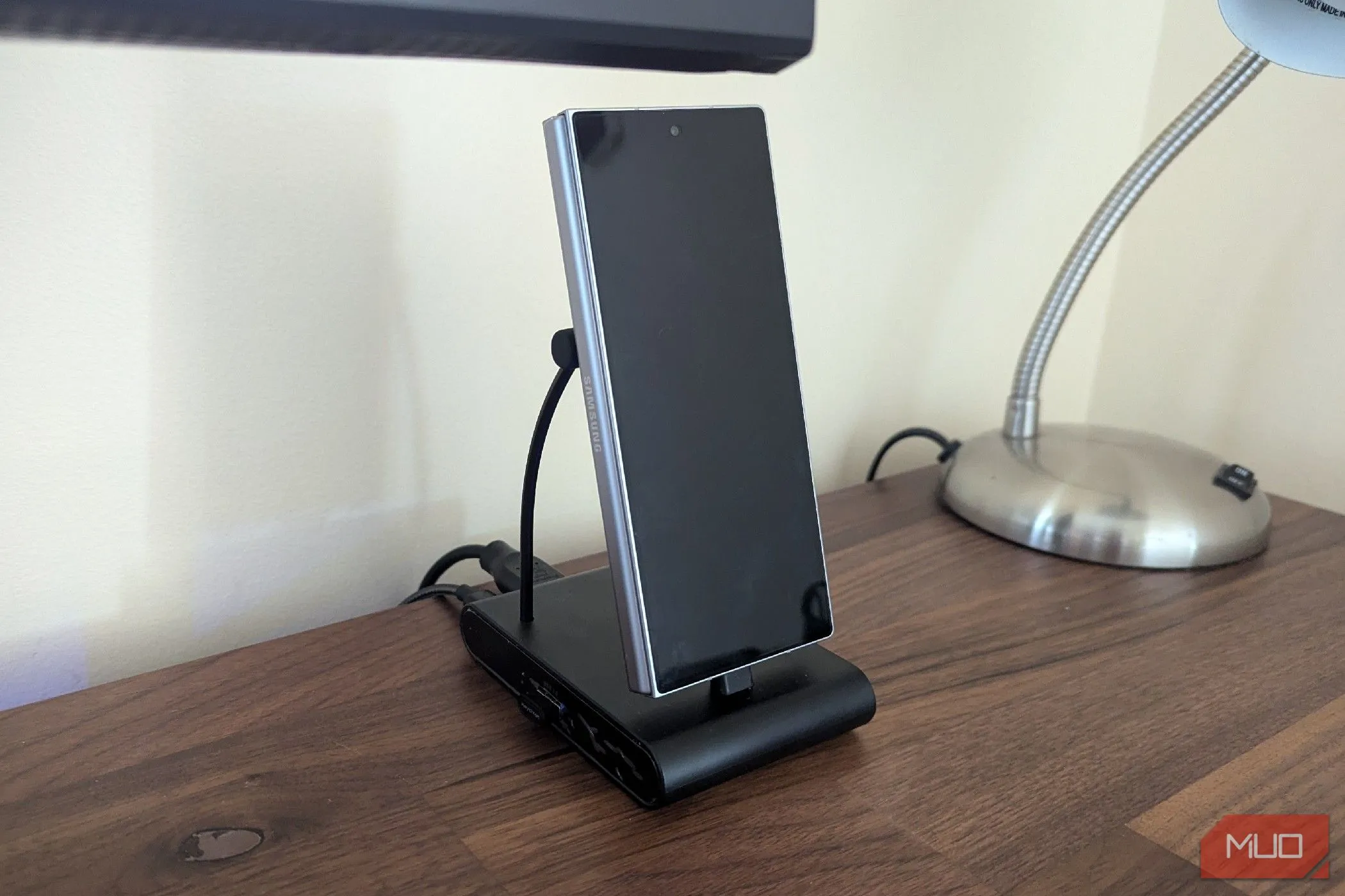 Điện thoại Samsung Galaxy Z Fold 6 đang được cắm vào đế sạc USB-C thẳng đứng, sẵn sàng cho chế độ desktop.