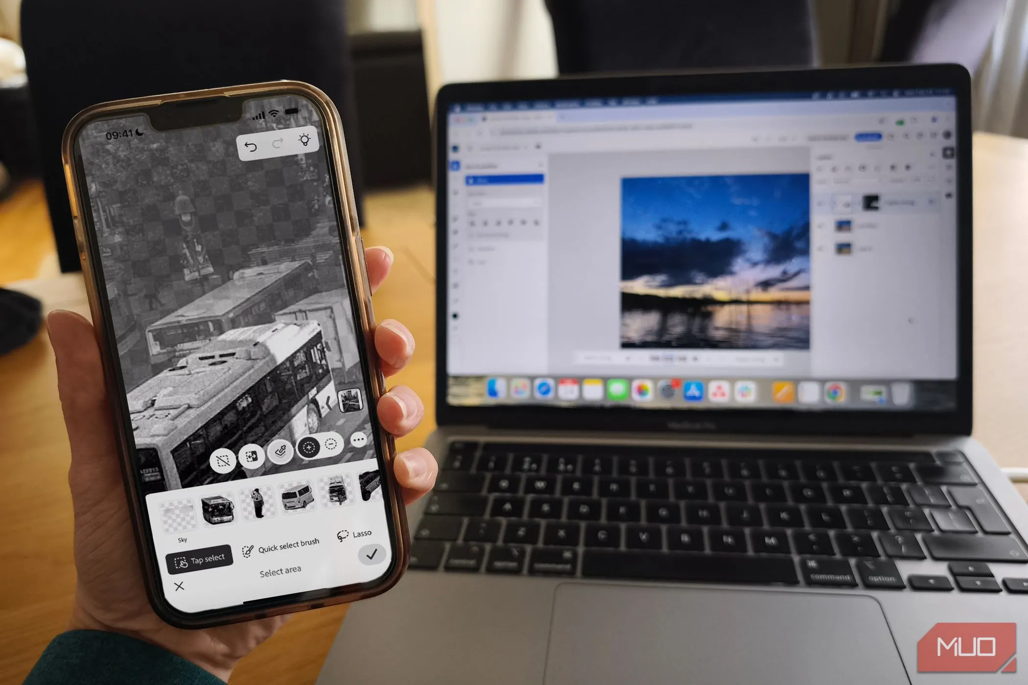Giao diện ứng dụng Photoshop Mobile trên điện thoại và Photoshop Web trên MacBook, minh họa sự đồng bộ giữa các nền tảng Adobe.