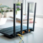 Hình ảnh bộ định tuyến Wi-Fi hiện đại với bốn ăng-ten trên bàn, biểu tượng của thiết bị mạng gia đình cần được bảo mật.