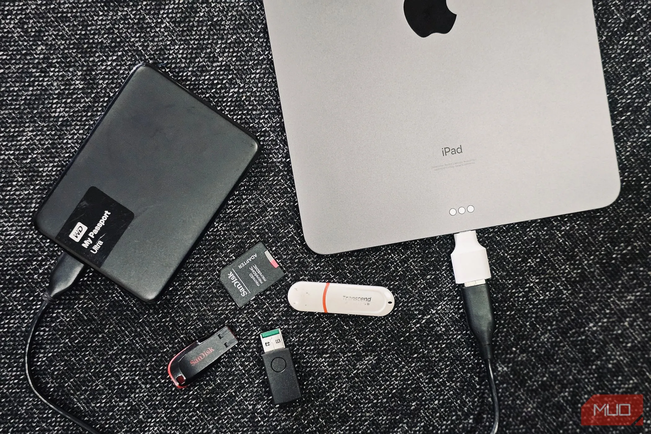 Hình ảnh minh họa các ổ đĩa gắn ngoài và iPad, tượng trưng cho việc quản lý và tổ chức dữ liệu trên các phân vùng khác nhau