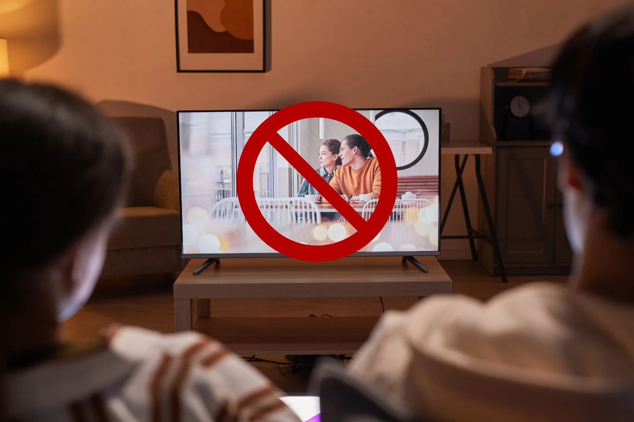 Hình ảnh minh họa cặp đôi xem TV, màn hình có biểu tượng cấm, ám chỉ việc dừng các ứng dụng giải trí khi kiểm tra tốc độ internet để có kết quả chính xác.