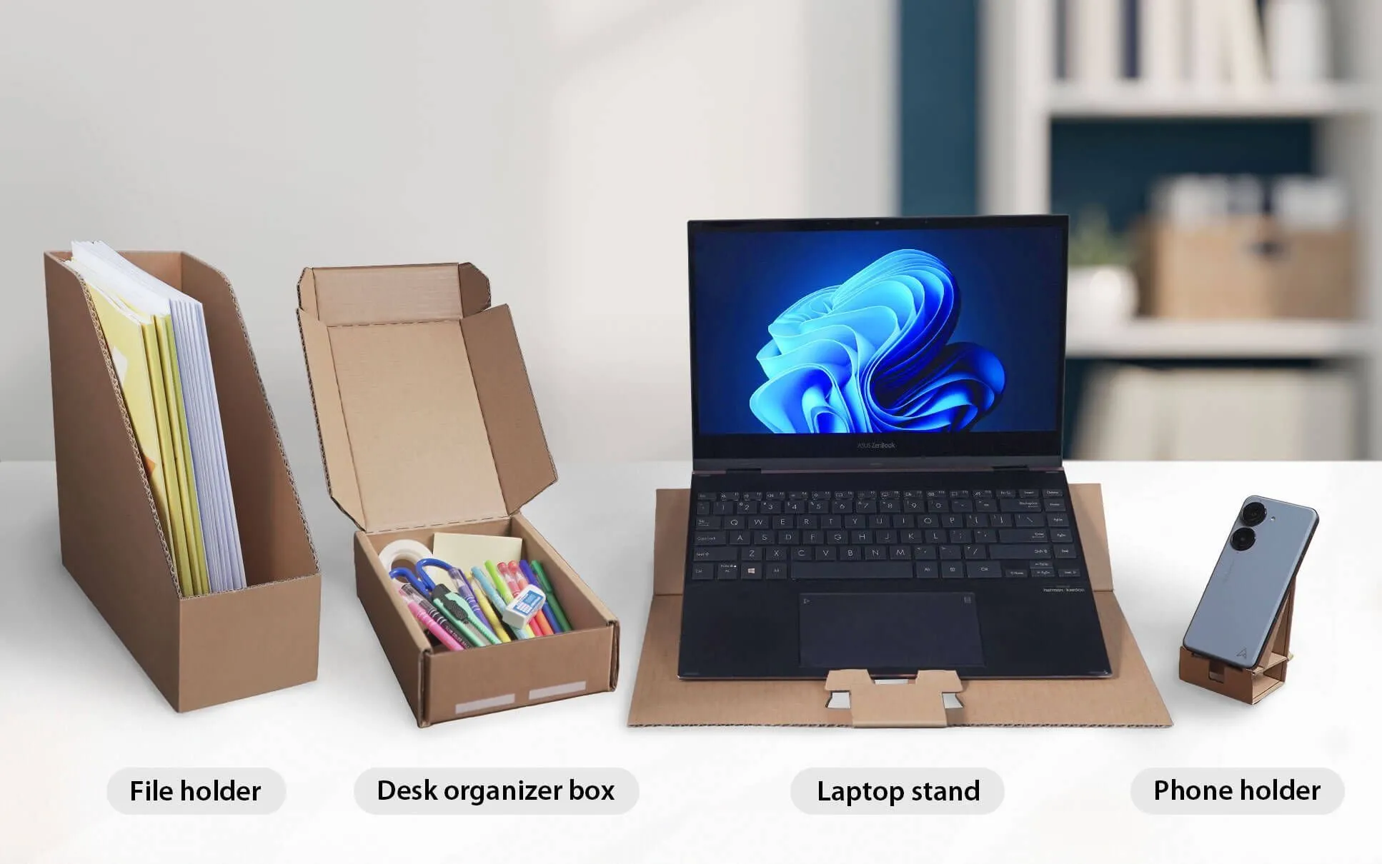 Hộp đựng màn hình Asus được biến đổi thành các phụ kiện bàn làm việc như giá đỡ điện thoại, giá laptop và hộp đựng văn phòng phẩm, minh họa khả năng tái sử dụng.