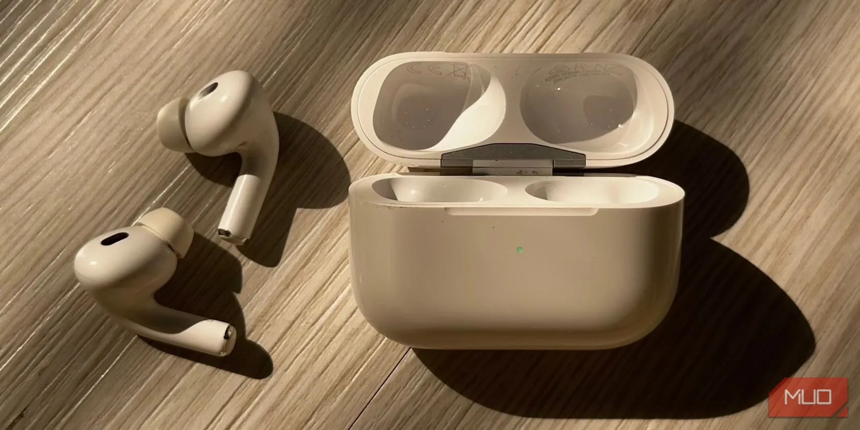 Hộp sạc AirPods với đèn trạng thái màu xanh lá cây, minh họa thiết kế ngang đặc trưng của AirPods thế hệ 3 hoặc AirPods Pro.
