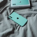 iPhone 11 đặt trên chăn ga giường màu kem