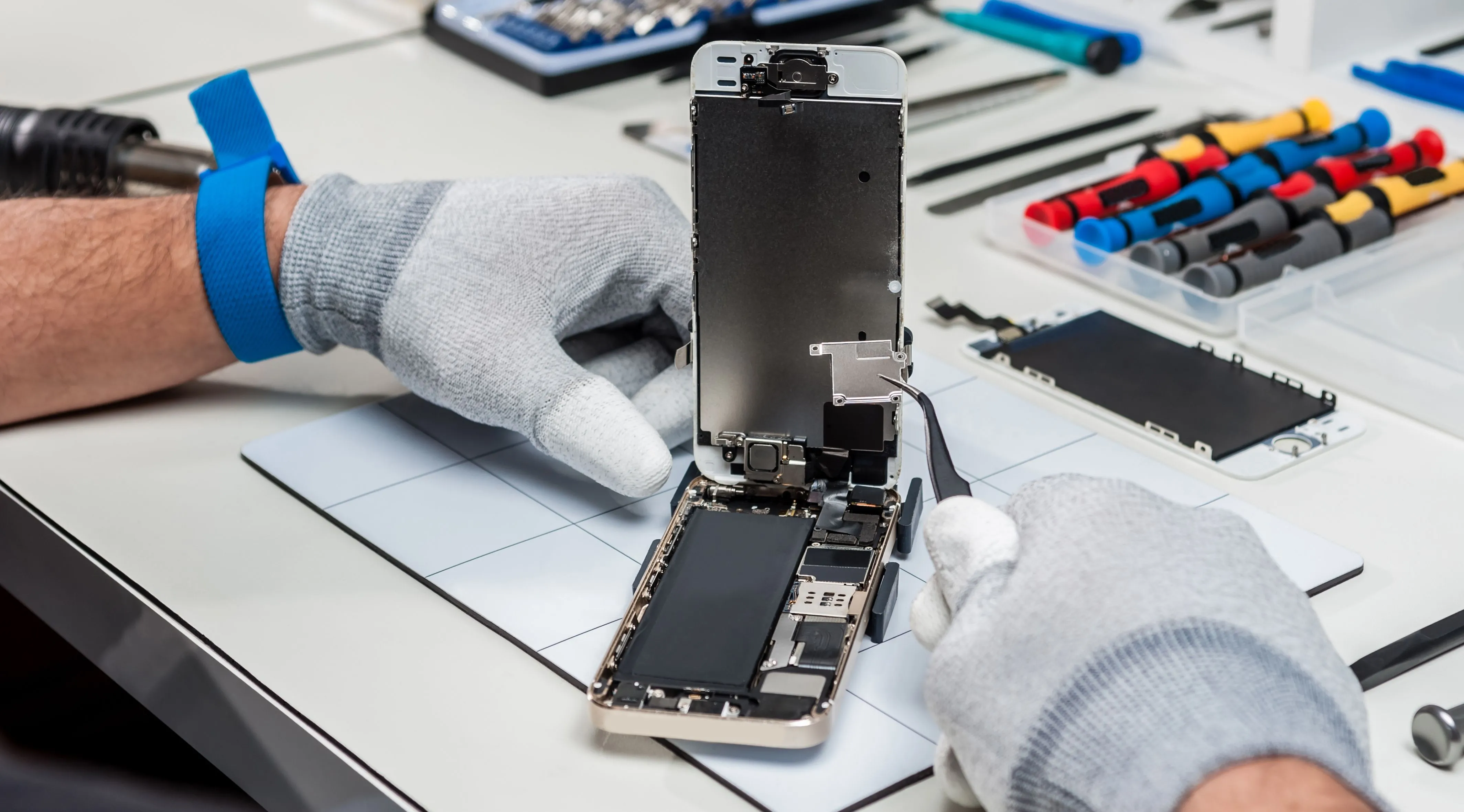Kỹ thuật viên đang tiến hành sửa chữa, thay thế linh kiện bên trong một chiếc smartphone