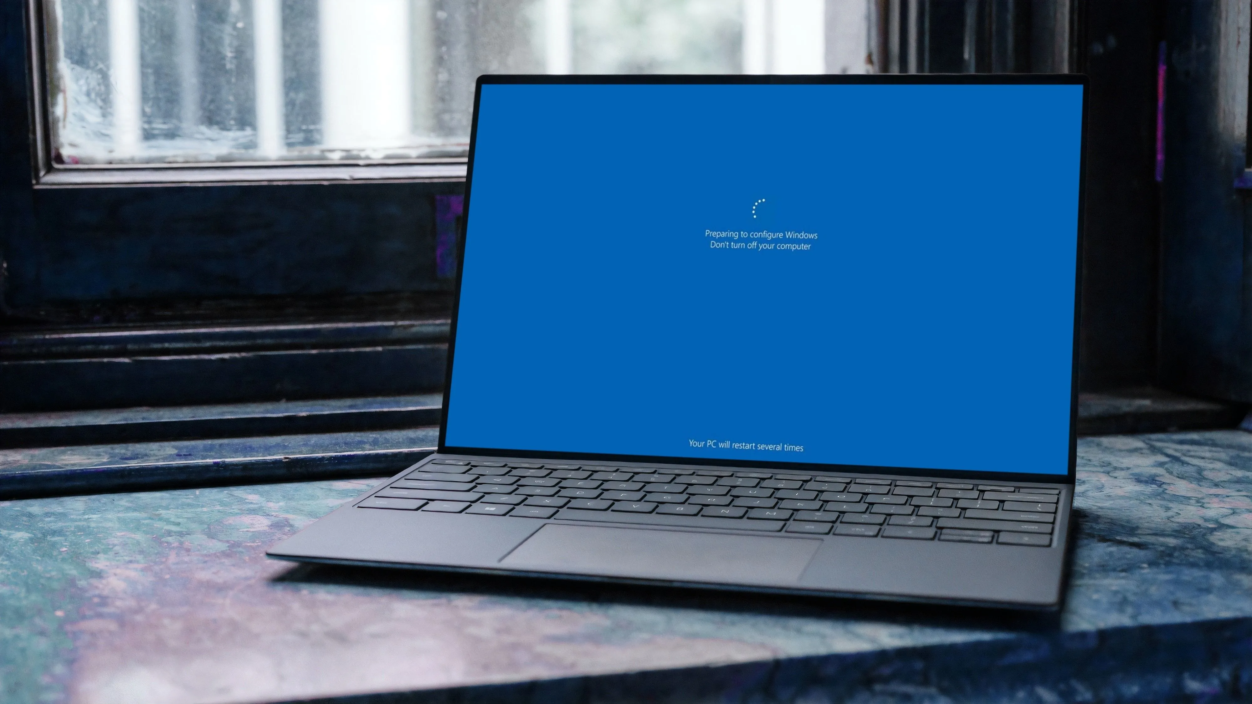 Laptop Windows 11 hiển thị màn hình đang cài đặt cập nhật hệ thống, cảnh báo nguy cơ lỗi File Explorer sau KB5051987