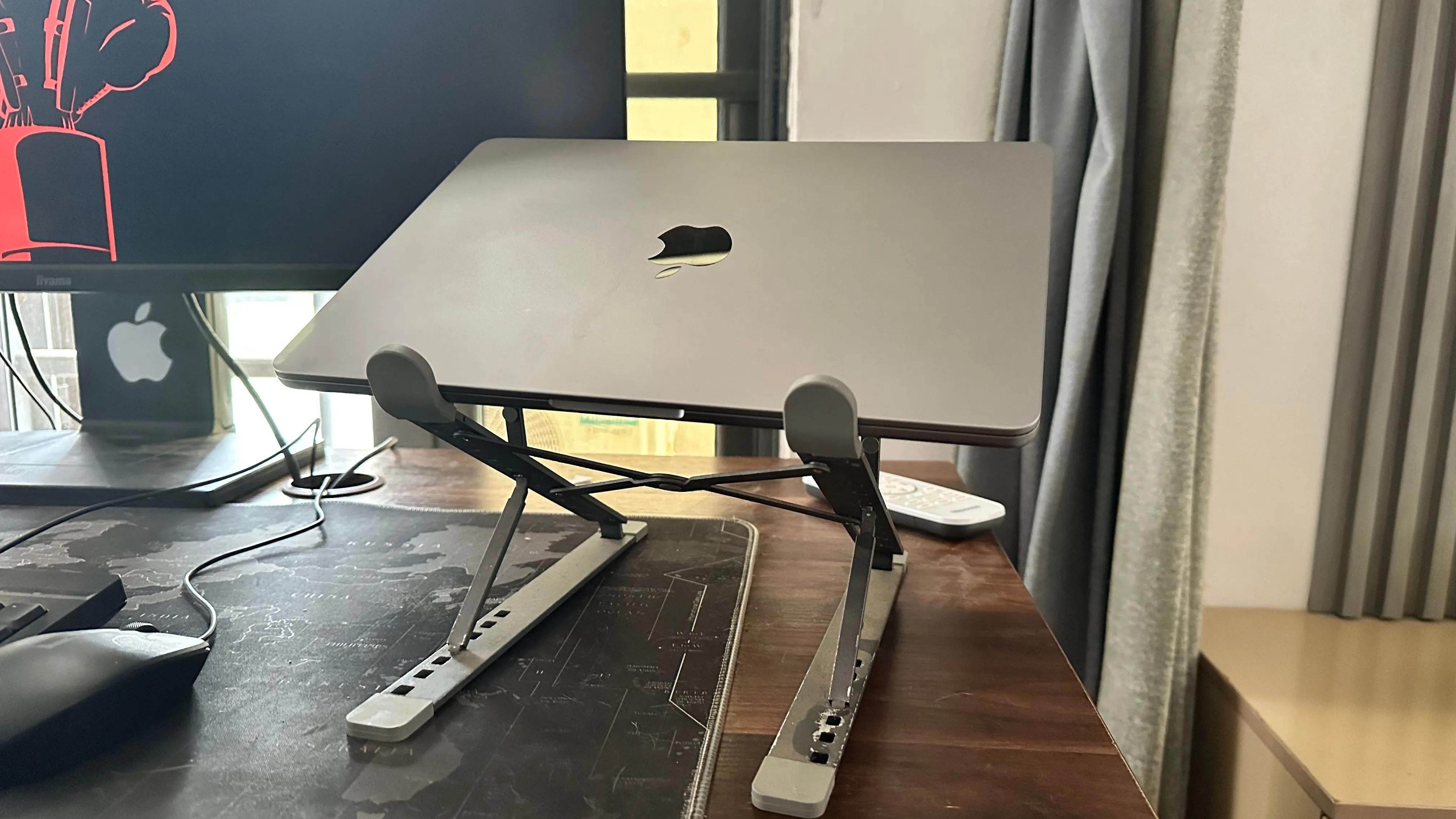 MacBook đặt trên giá đỡ cạnh màn hình ngoài, gợi ý cách tản nhiệt hiệu quả để bảo vệ pin