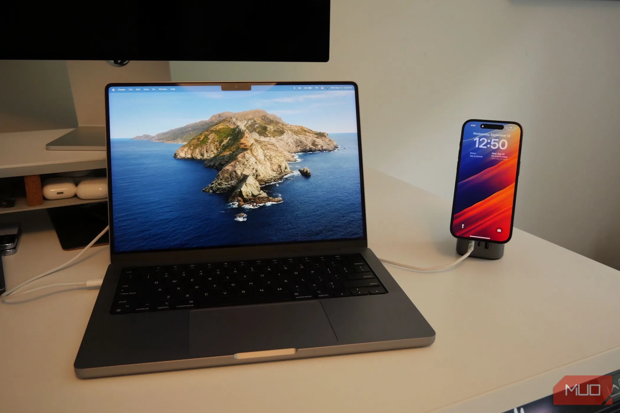 MacBook Pro và iPhone đang sạc, thể hiện việc sử dụng iPhone như một loa ngoài