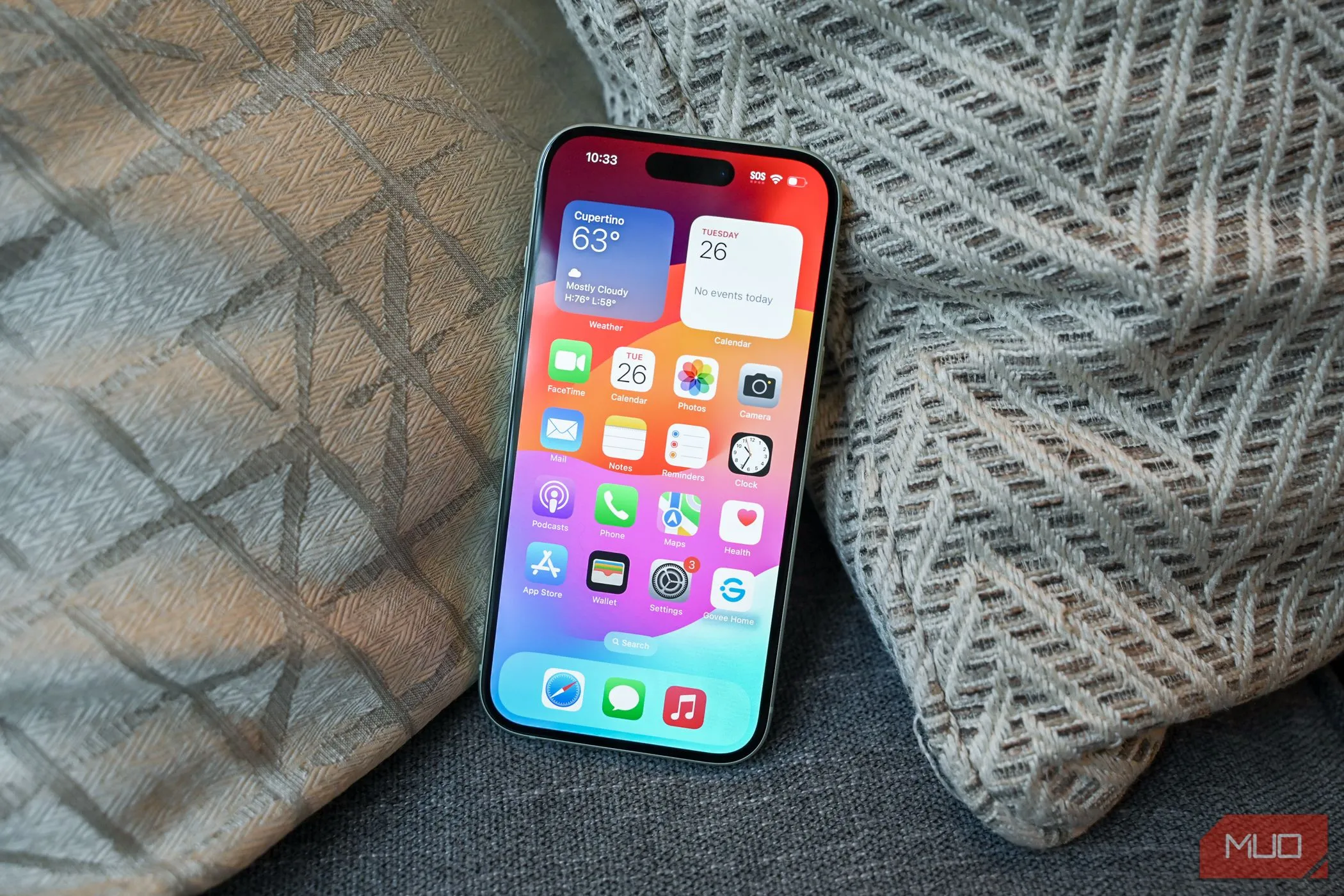 Màn hình chính của iPhone 15 hiển thị giao diện iOS 26, minh họa thiết bị tương thích
