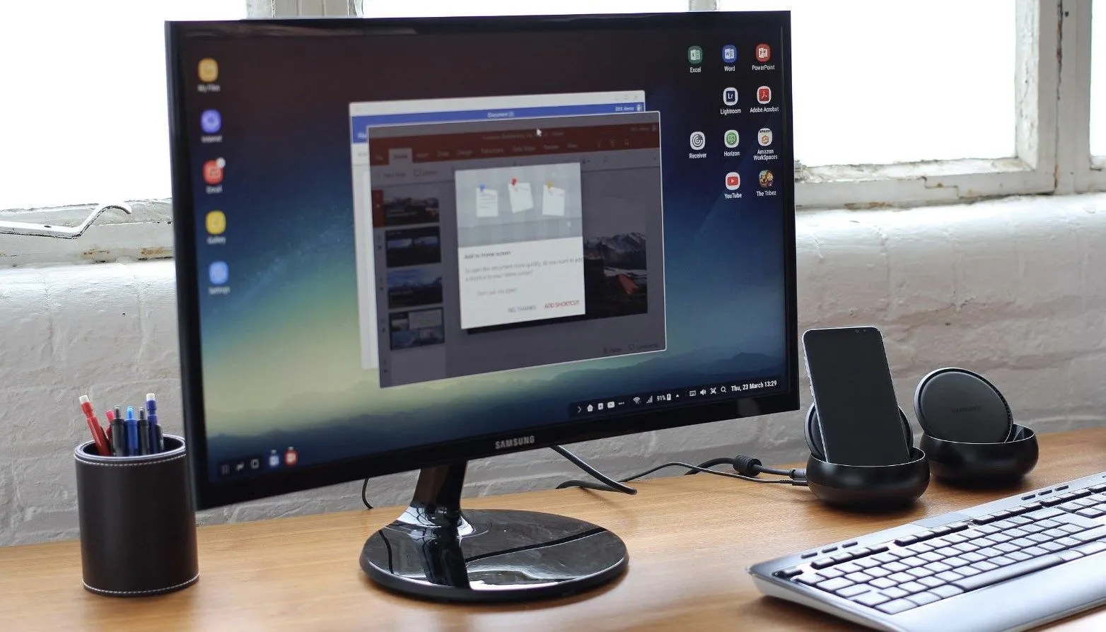 Màn hình Samsung hiển thị giao diện DeX, bàn phím và chuột không dây hỗ trợ trải nghiệm máy tính để bàn.