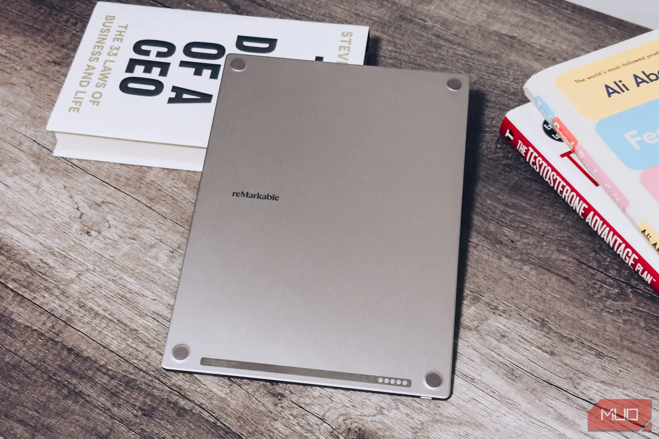 Mặt sau của reMarkable Paper Pro đặt trên bàn gỗ, cạnh những cuốn sách