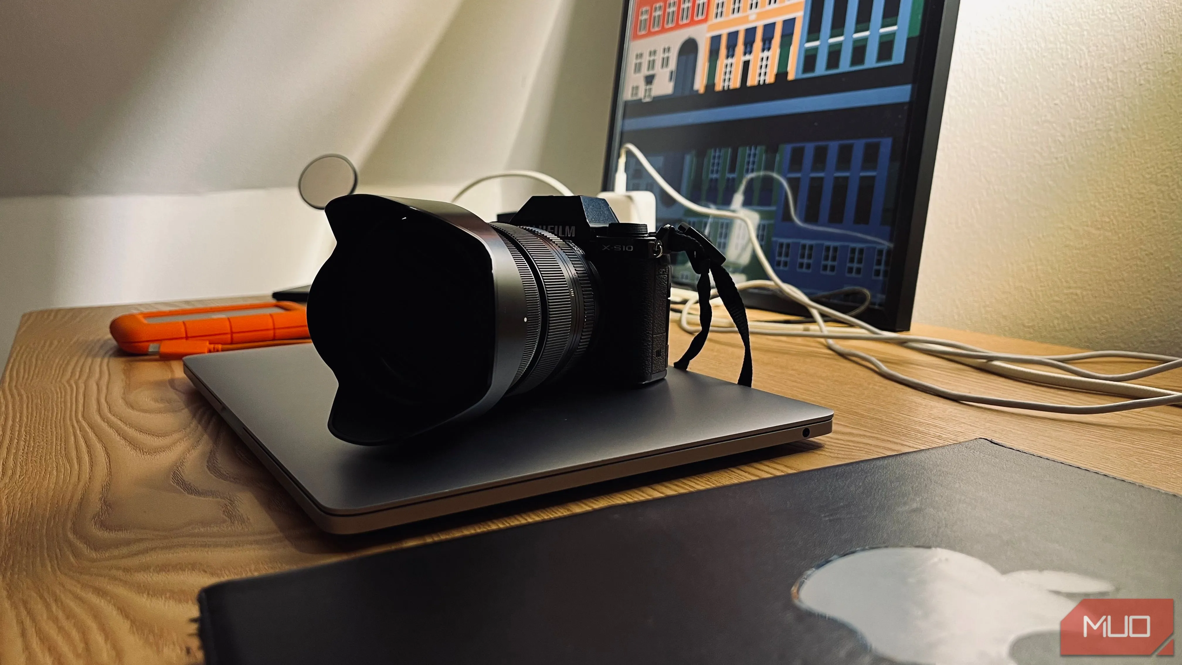 Máy ảnh và laptop đặt chồng lên nhau, thể hiện cách sắp xếp thiết bị công nghệ để chụp ảnh độc đáo.