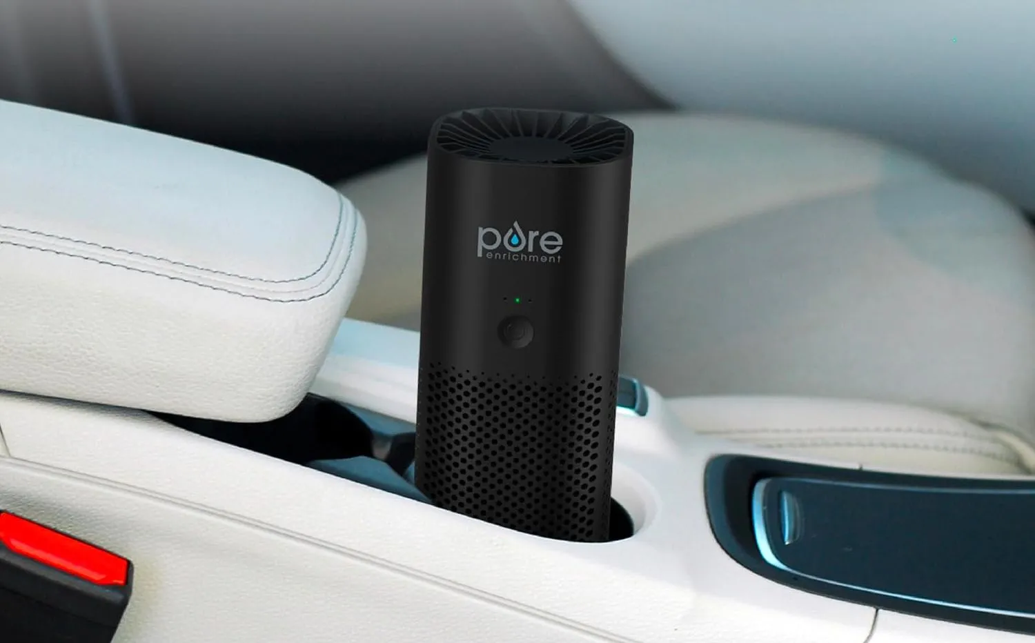 Máy lọc không khí PureZone Mini di động đặt trong hộc đựng cốc của xe hơi, giúp làm sạch không khí bên trong.