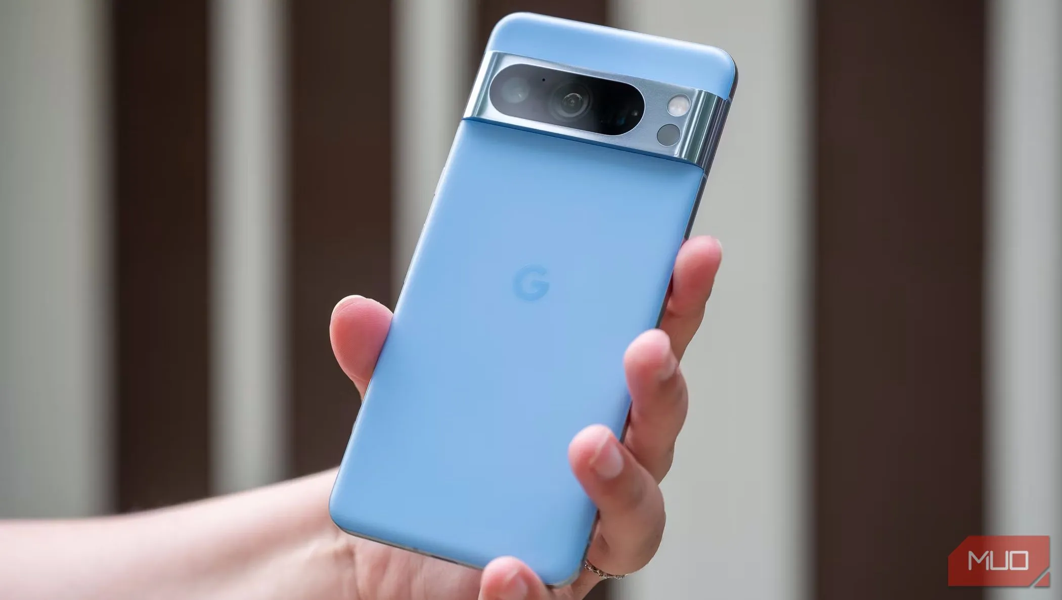 Một người đàn ông đang cầm điện thoại Pixel 8 Pro để lộ mặt lưng màu đen