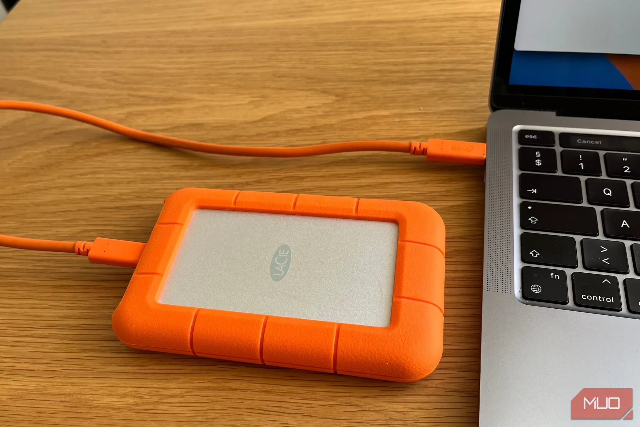 Một ổ cứng gắn ngoài được cắm vào cổng USB của máy tính xách tay, minh họa việc lưu trữ dữ liệu vật lý trong quy tắc sao lưu 3-2-1.