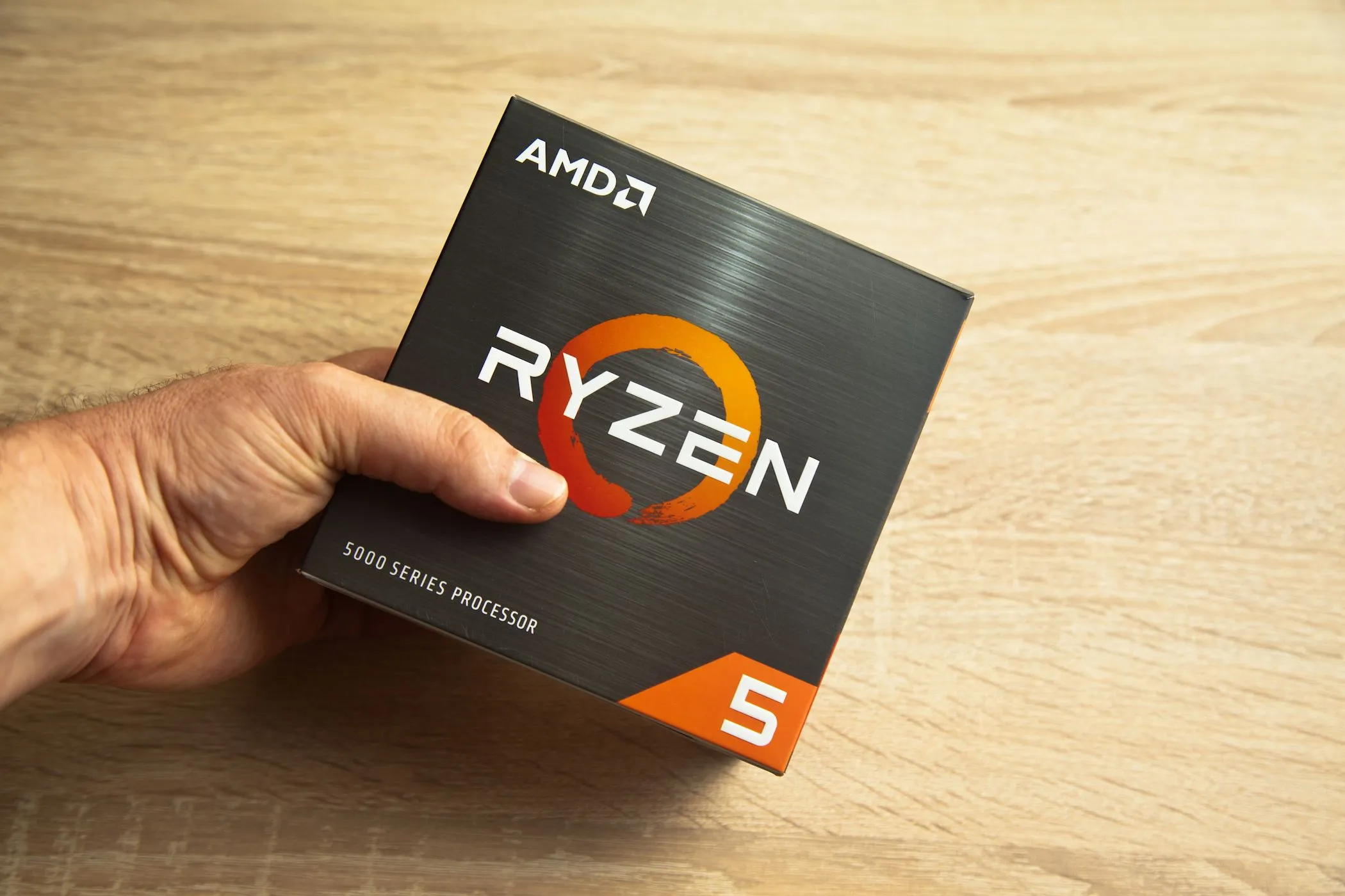 Người đàn ông cầm hộp bộ vi xử lý AMD Ryzen 5000 Series