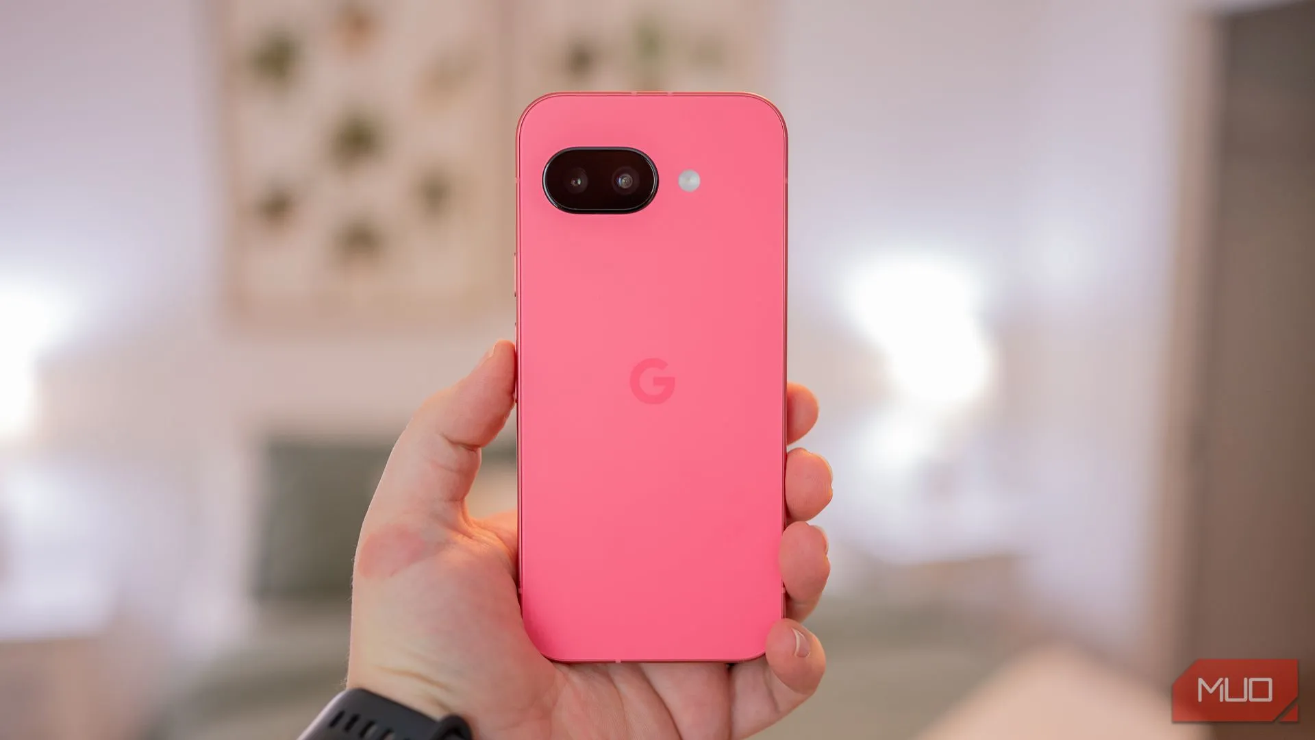 Người dùng cầm điện thoại Google Pixel 9a màu Iris, khoe mặt lưng kính mờ và khung kim loại sang trọng