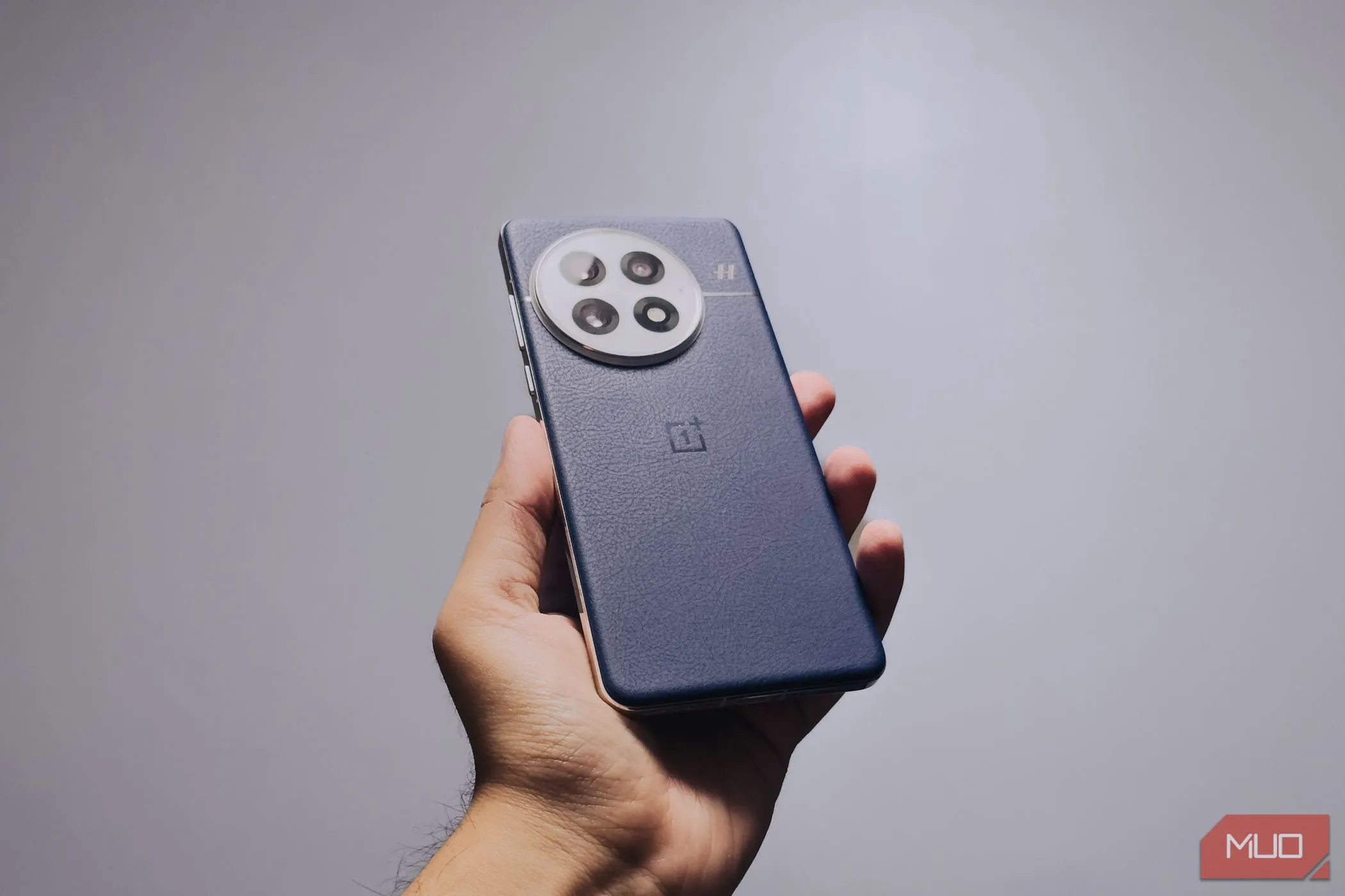 Người dùng cầm OnePlus 13 trong tay, thể hiện cảm giác cầm nắm chắc chắn và công thái học được cải thiện của thiết bị.