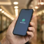 Người dùng đang cầm điện thoại xem logo WhatsApp với tính năng phiên âm tin nhắn thoại