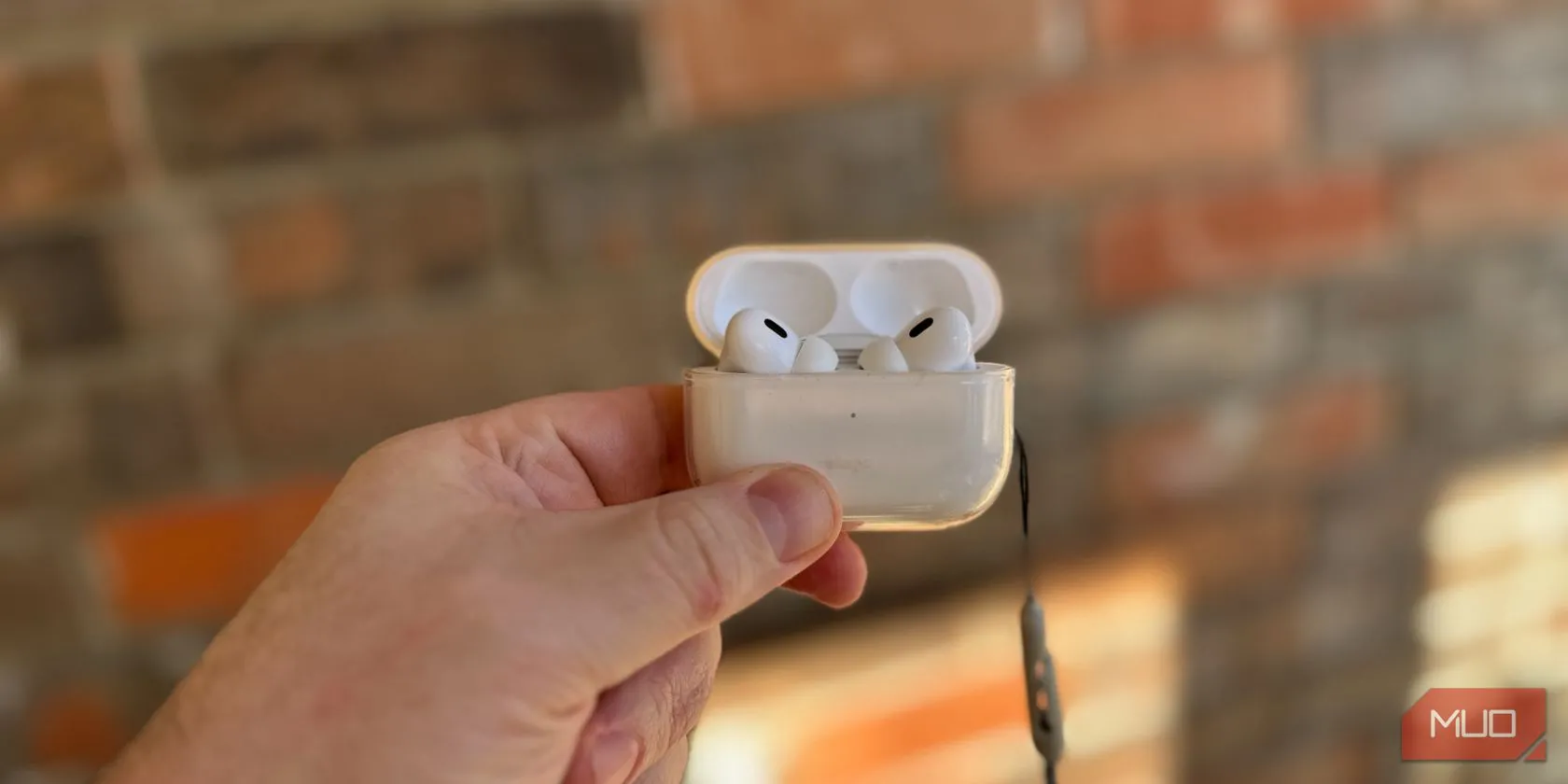 Người dùng đang cầm hộp sạc tai nghe AirPods Pro 2 màu trắng