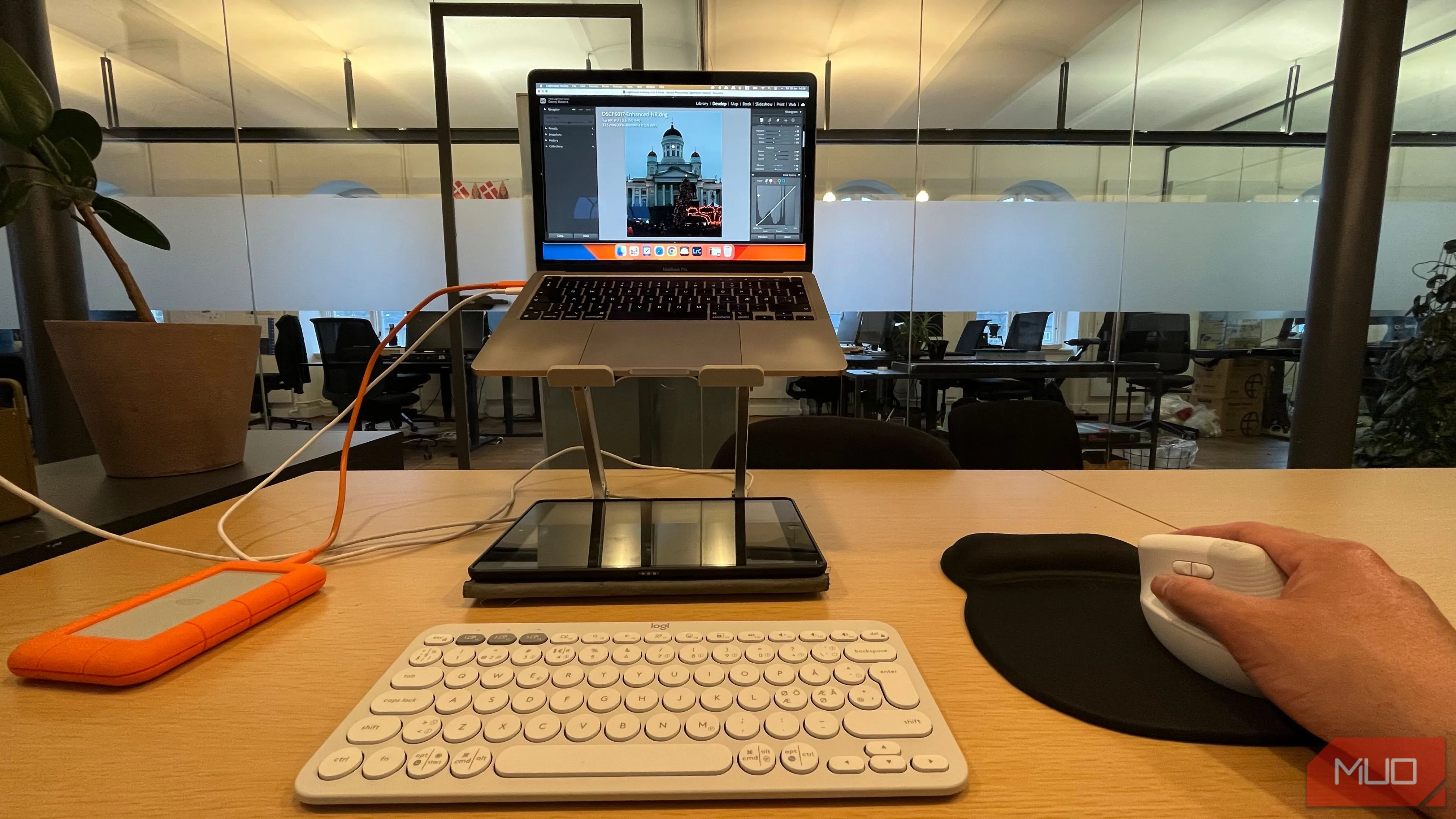 Người dùng đang chỉnh sửa ảnh trên laptop bằng chuột không dây, thao tác chính xác và hiệu quả hơn trackpad.