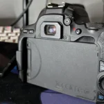 Người dùng nhìn qua kính ngắm quang học của máy ảnh DSLR Canon 200D, thể hiện ưu điểm không độ trễ của viewfinder quang học.