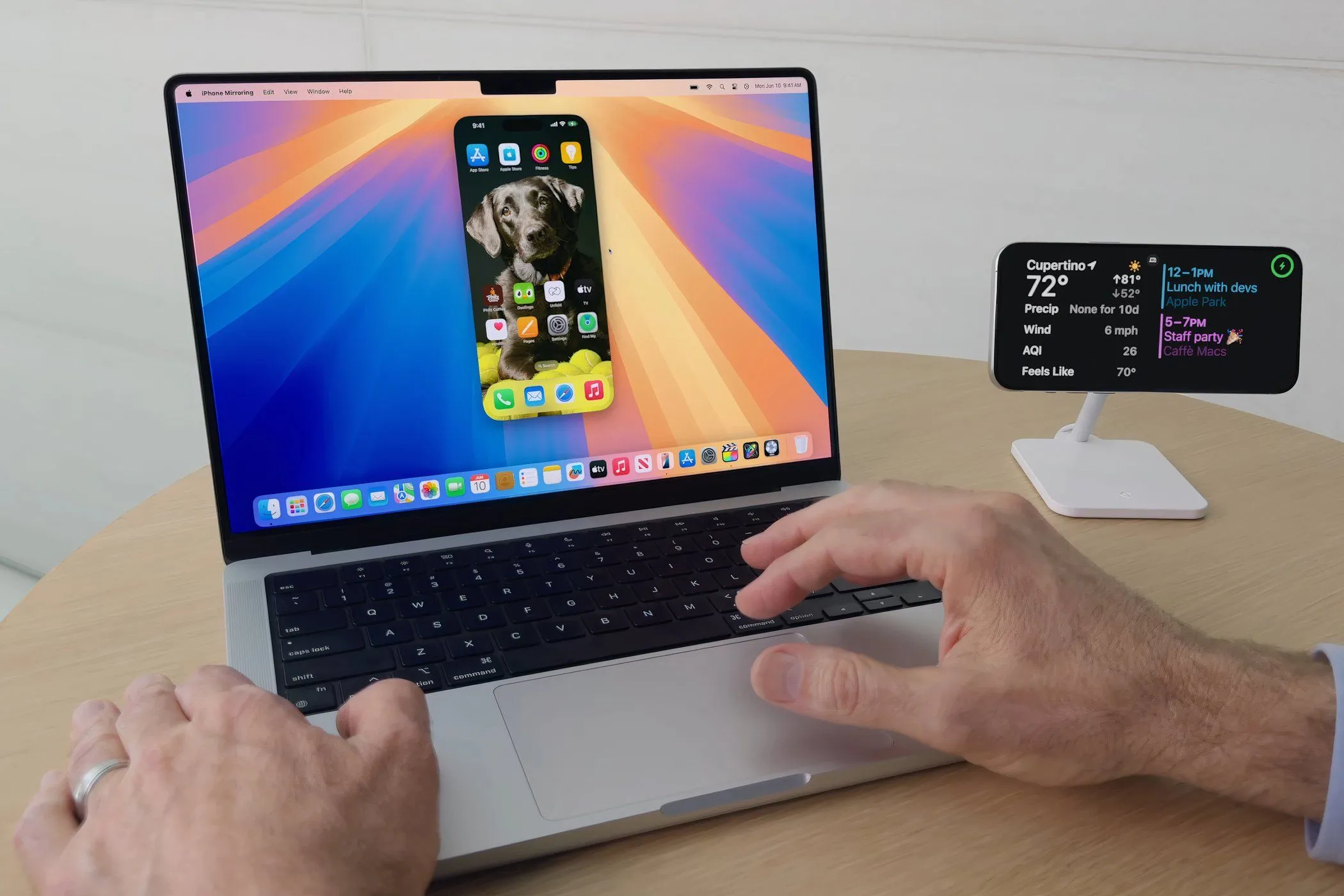 Người dùng thao tác iPhone trên MacBook Pro với tính năng iPhone Mirroring của macOS Sequoia, tối ưu hóa quy trình làm việc