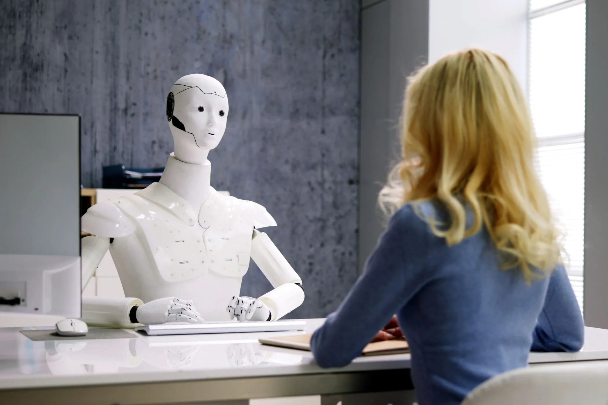 Người phụ nữ phỏng vấn robot AI, minh họa khả năng tương tác tự chủ của AI agent trong môi trường làm việc.
