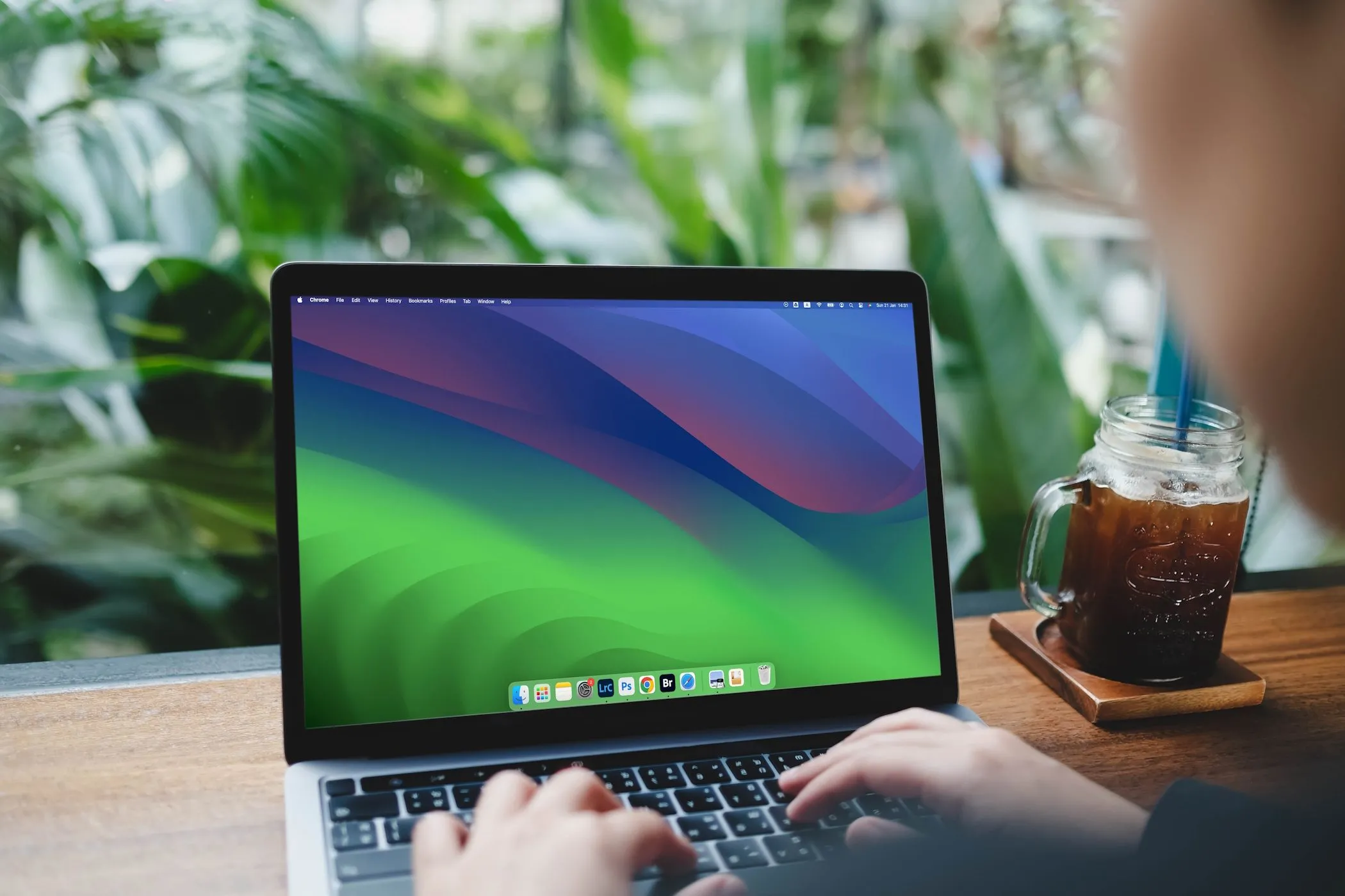 Người phụ nữ sử dụng MacBook Air để nghiên cứu thông tin và đánh giá độ uy tín của một công ty, minh họa việc chủ động phòng tránh lừa đảo online.