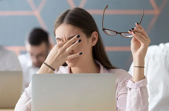 Người phụ nữ xoa mắt biểu hiện mỏi mắt kỹ thuật số, liên quan đến tác động của Dark Mode