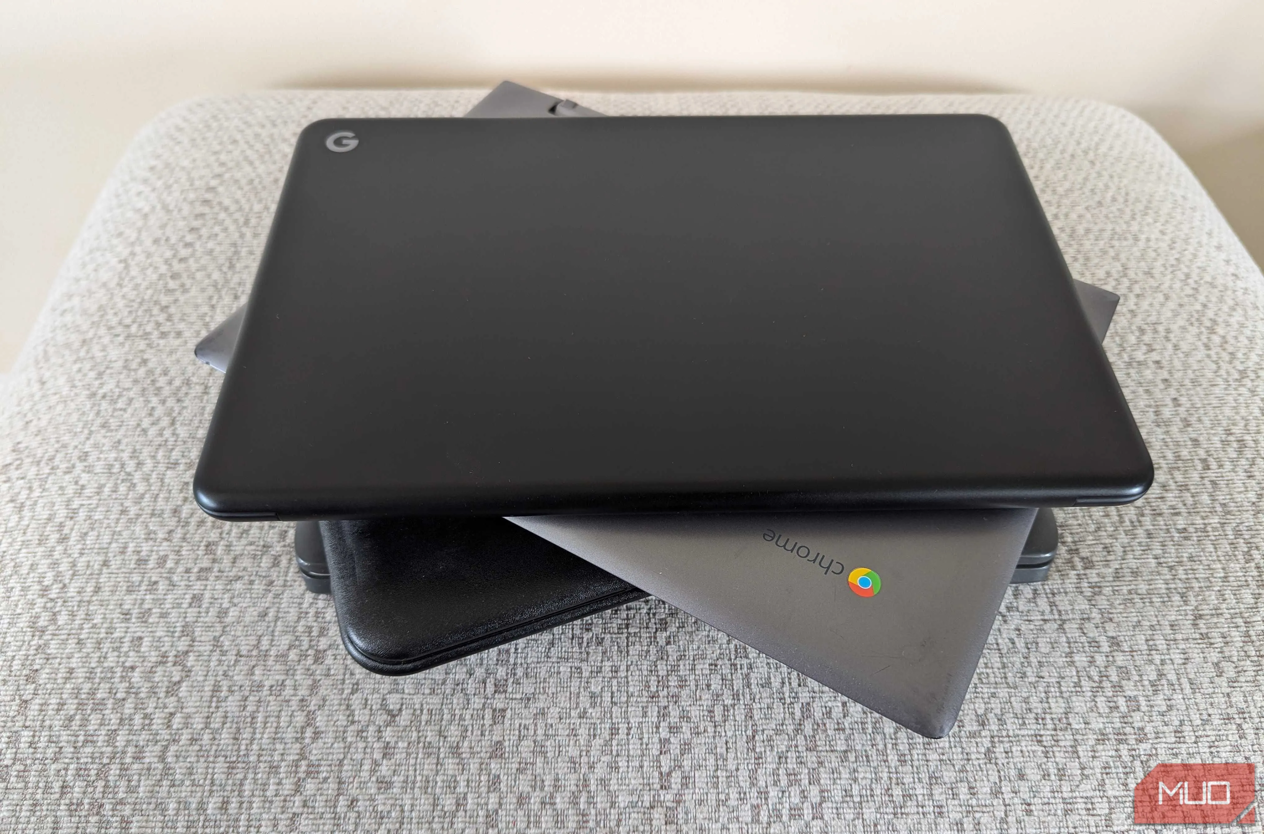 Nhiều chiếc Chromebook xếp chồng lên nhau trên ghế đẩu, thể hiện tính gọn nhẹ và di động của chúng