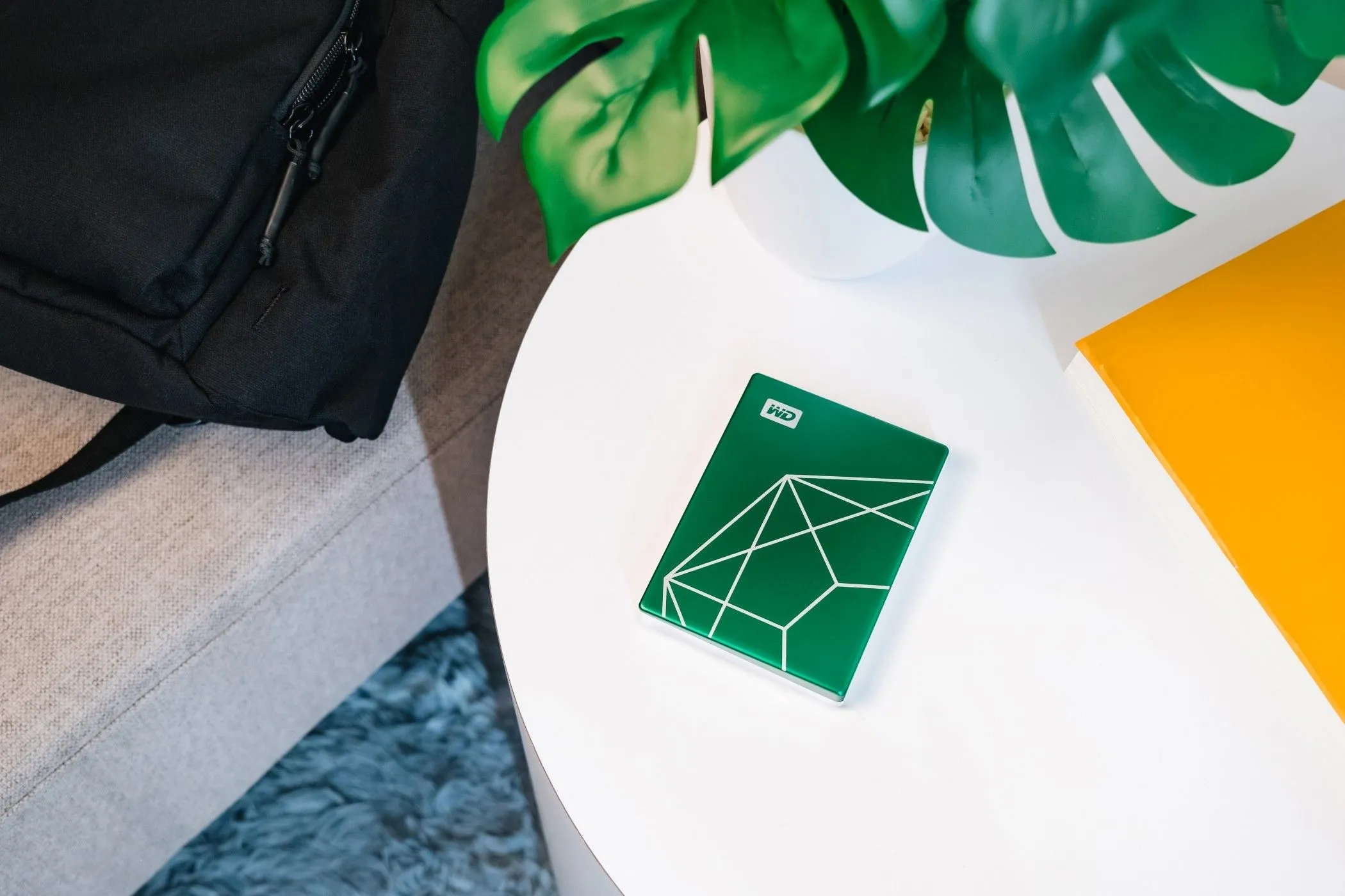 Ổ cứng WD My Passport Ultra 20th Anniversary Edition 2TB trên bàn làm việc, minh họa vật liệu thân thiện môi trường