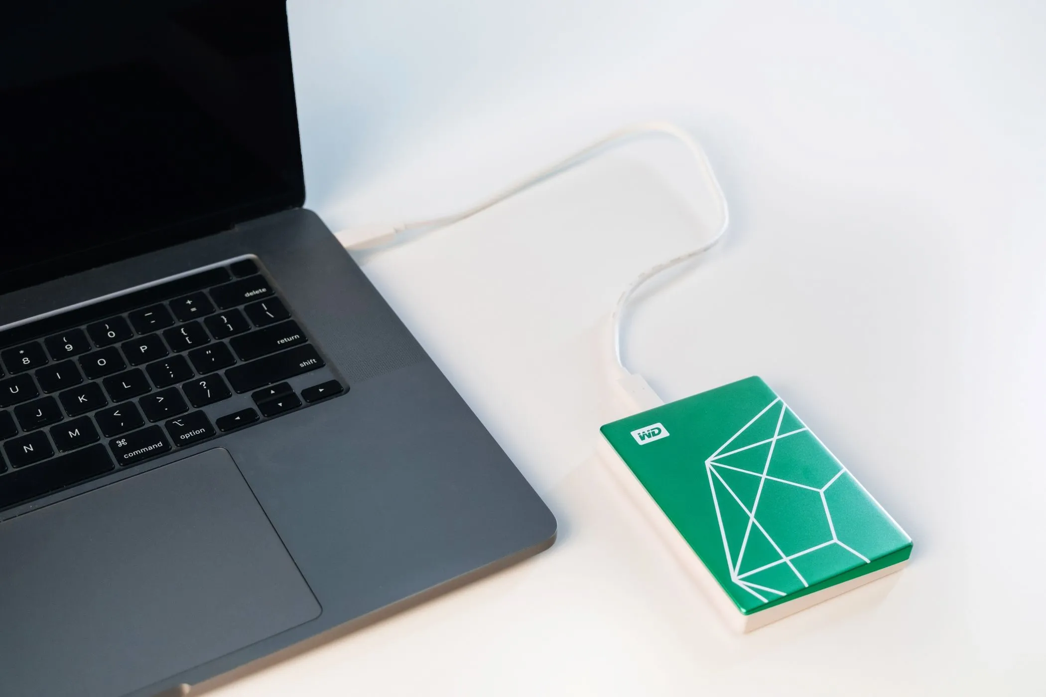 Ổ cứng WD My Passport Ultra Emerald kết nối với máy tính xách tay, thể hiện tính năng sao lưu và bảo mật dữ liệu dễ dàng