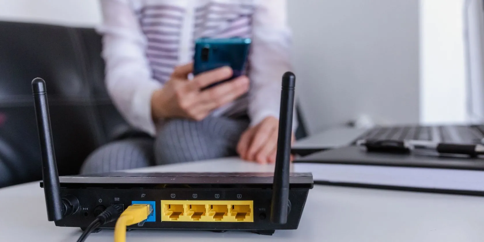 Router Wi-Fi hoạt động trong không gian gia đình, hình ảnh người dùng mờ phía sau