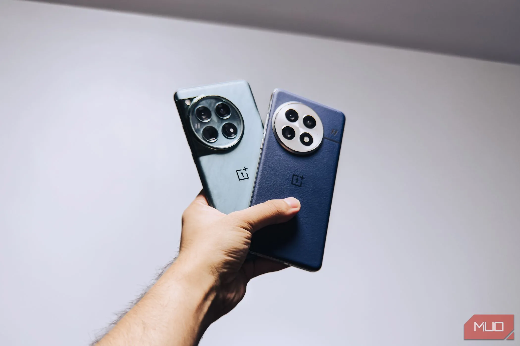 So sánh trực quan OnePlus 13 (bên trái) và OnePlus 12 (bên phải) khi đặt cạnh nhau trong tay, cho thấy sự khác biệt về hình dáng và kích thước.