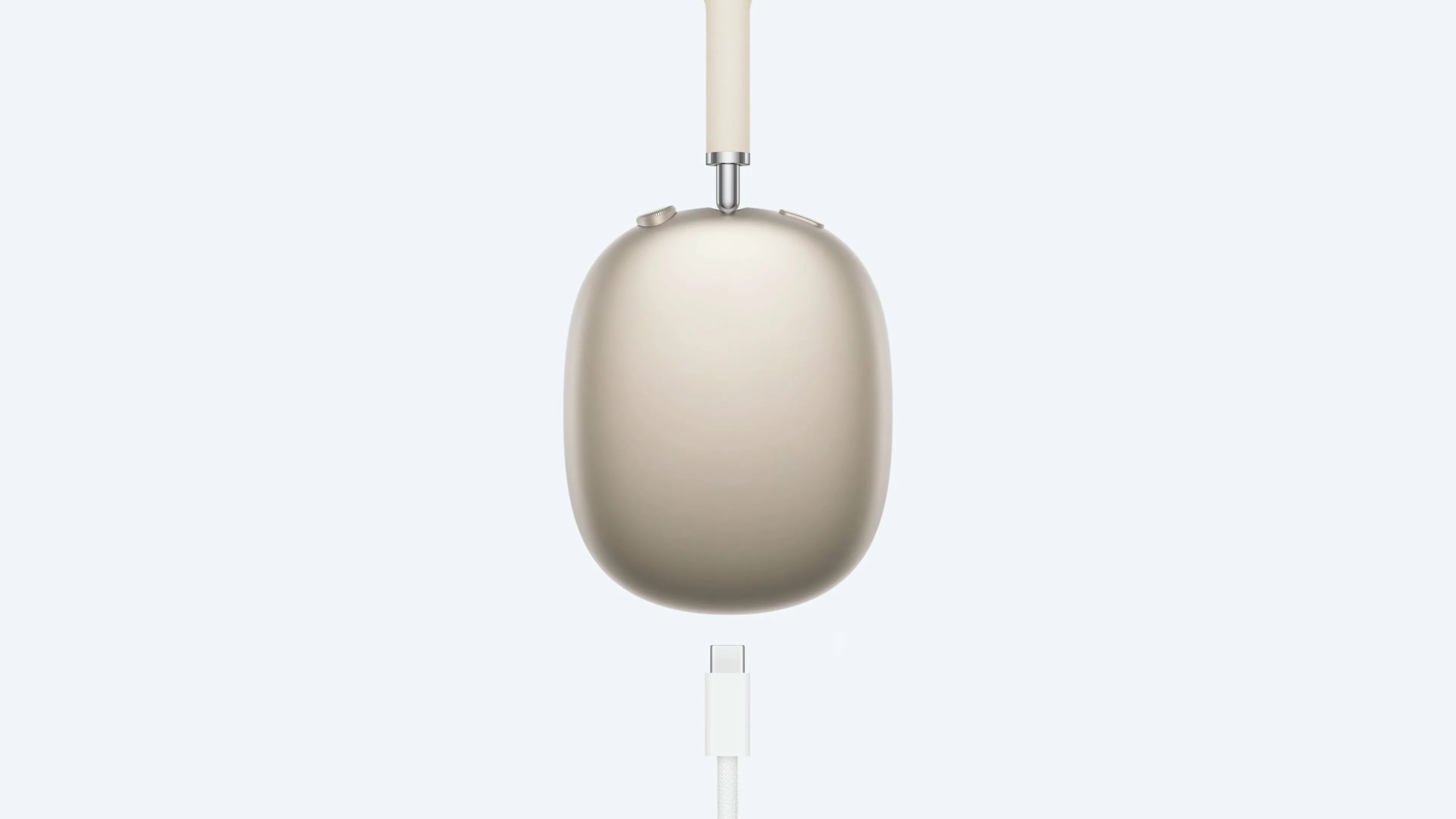 Tai nghe AirPods Max màu Starlight đang sạc với cáp USB-C