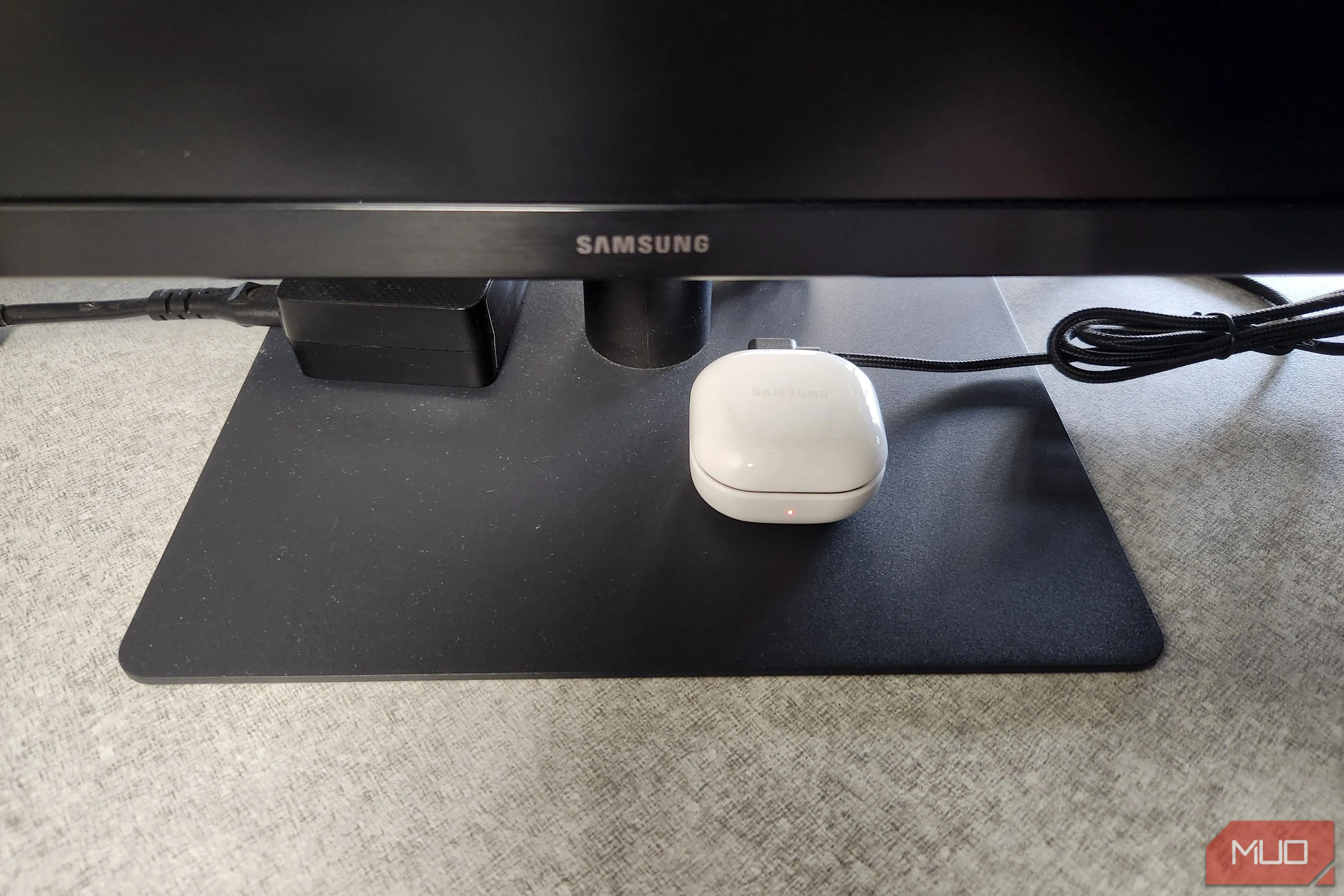 Tai nghe Bluetooth đang sạc pin qua cổng USB trên màn hình máy tính.