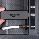 Thiết bị Amazon Fire TV Stick cắm vào cổng HDMI của Smart TV, dây ăng-ten bị cắt, minh họa việc sử dụng Smart TV và các thiết bị ngoại vi liên quan đến thu thập dữ liệu.