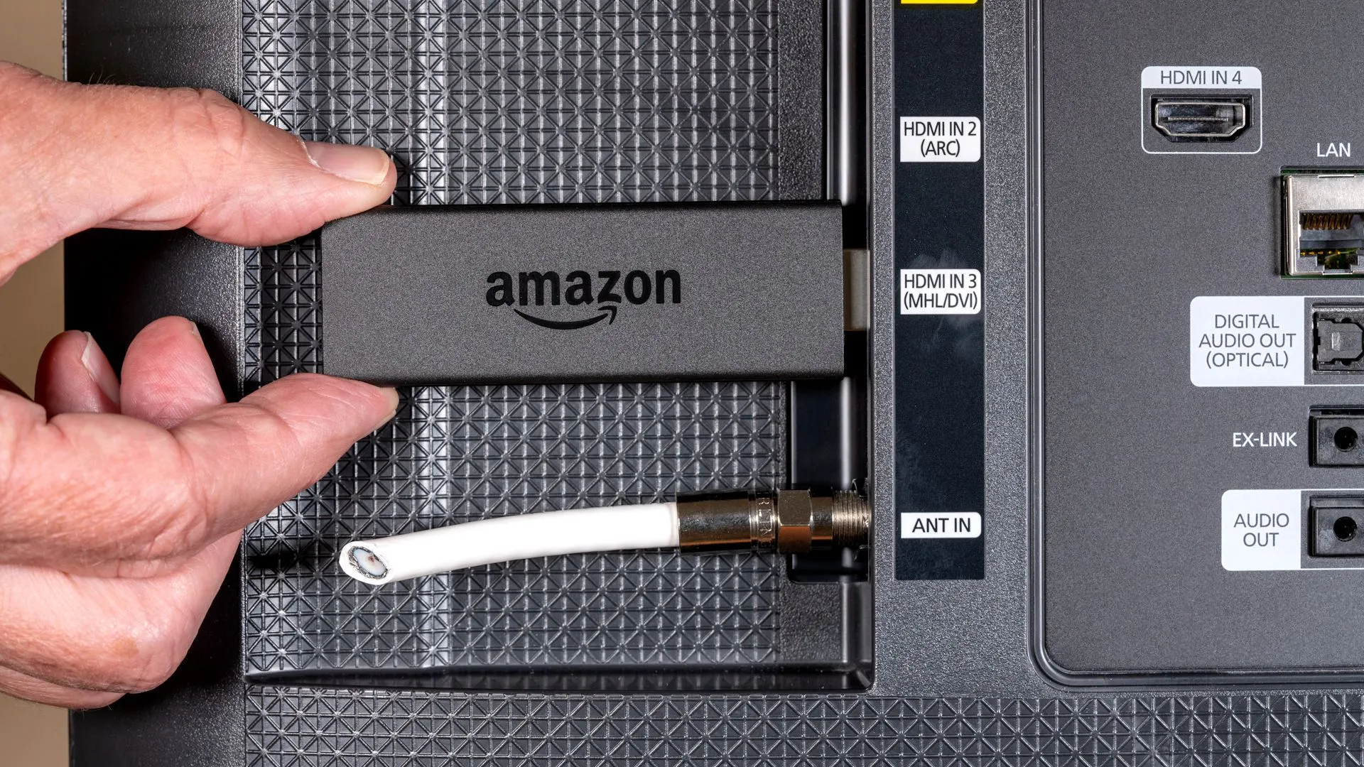 Thiết bị Amazon Fire TV Stick cắm vào cổng HDMI của Smart TV, dây ăng-ten bị cắt, minh họa việc sử dụng Smart TV và các thiết bị ngoại vi liên quan đến thu thập dữ liệu.