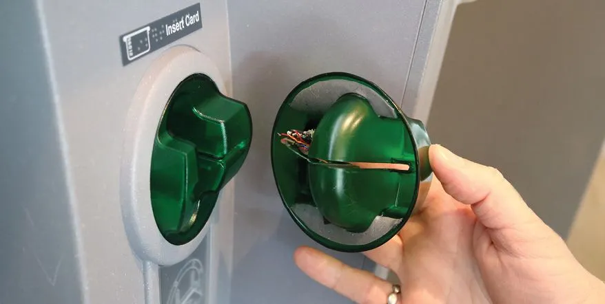 Thiết bị skimming thẻ được đặt chồng lên khe đọc thẻ thật.