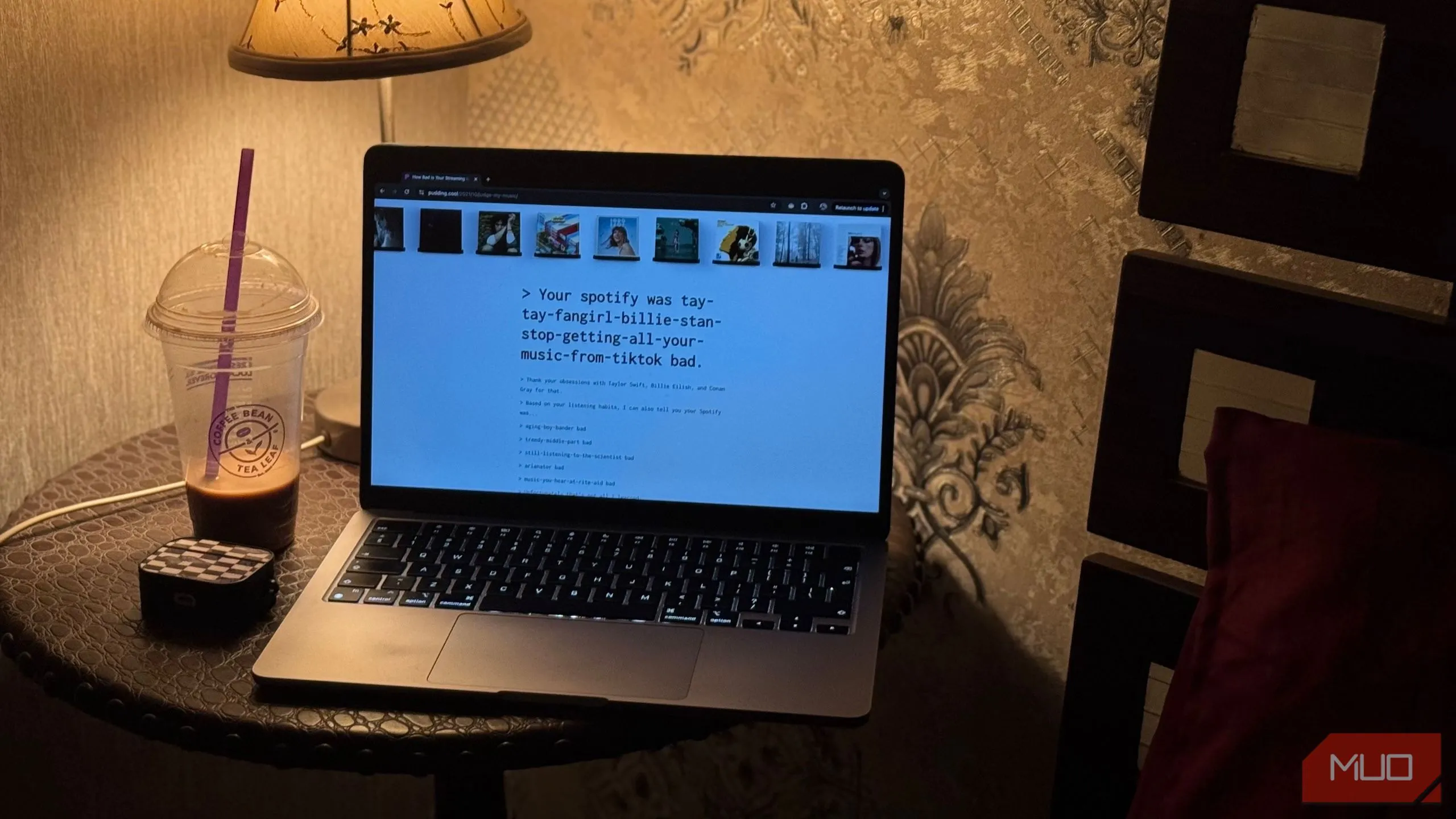 Trang web 'How Bad is Your Streaming Music' hiển thị trên MacBook, cạnh cốc cà phê, minh họa trải nghiệm duyệt web thông thường.