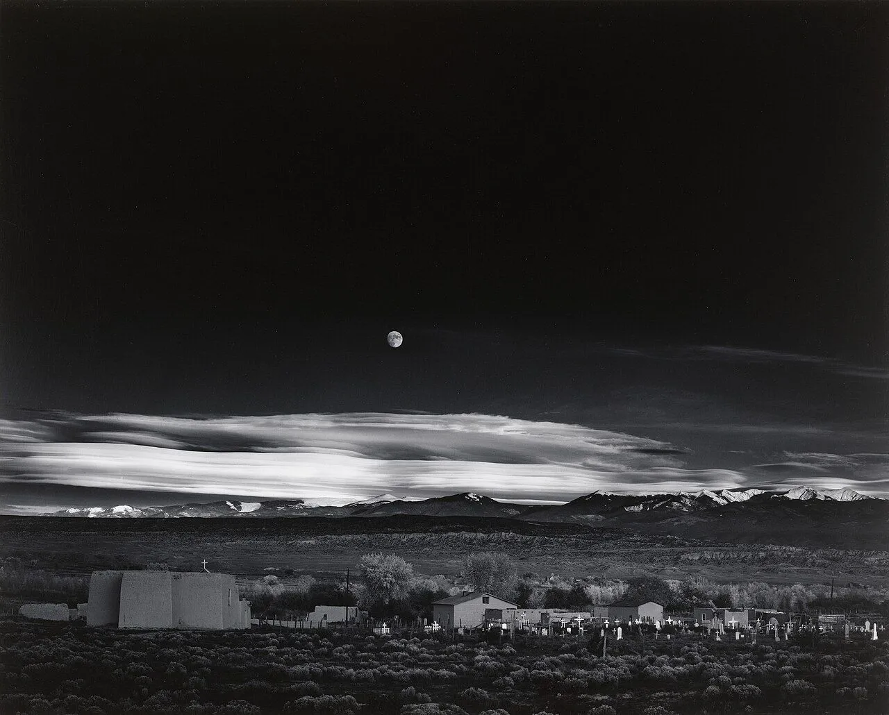 Tuyệt tác &quot;Moonrise, Hernandez, New Mexico&quot; của Ansel Adams, với mặt trăng mọc trên thị trấn sa mạc, nổi bật tương phản.